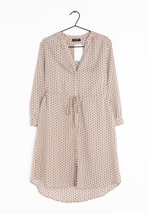 Vestito beige chiaro a pois neri, con scollo a V, maniche lunghe, vita con laccio e orlo leggermente curvo. Tessuto dalla texture liscia.