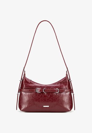 Bordowa skórzana torebka w kształcie łuku, z akcentami w srebrnym kolorze, podwójnymi uchwytami i teksturowaną powierzchnią. Zamek błyskawiczny na górze.