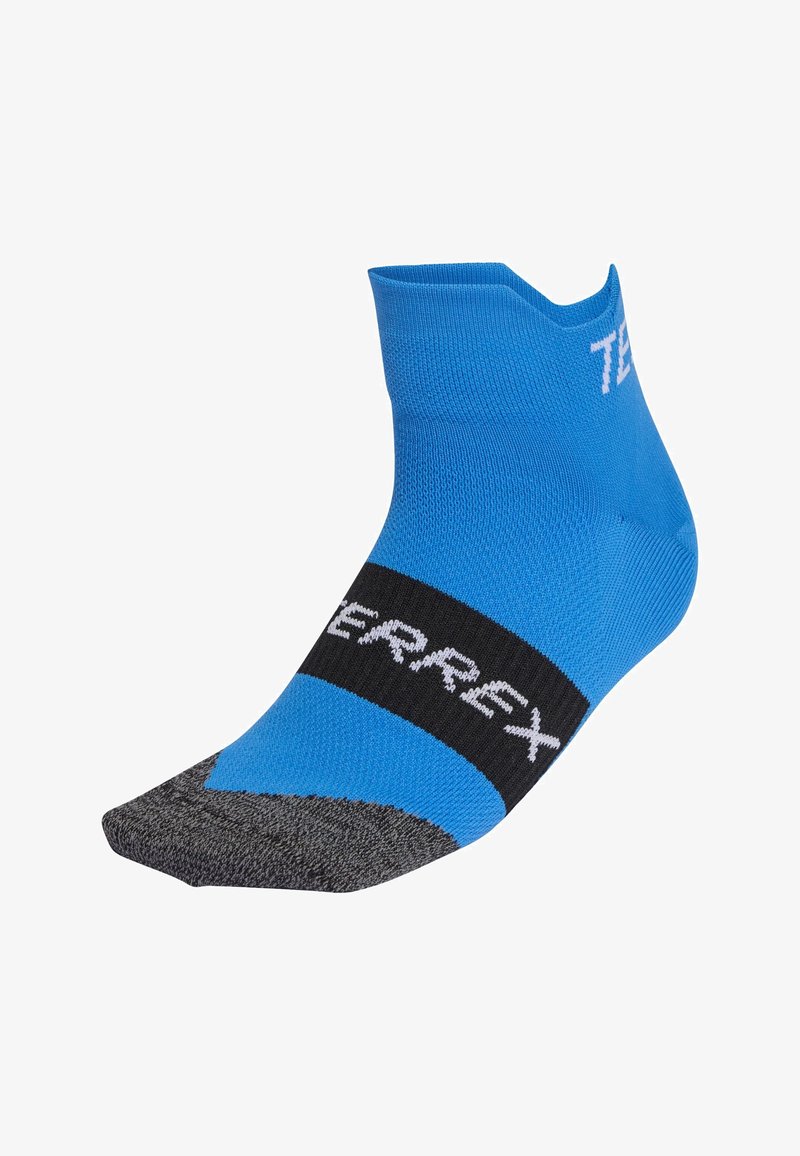 Calcetín deportivo azul con puntera gris, con una banda negra etiquetada "TERREX." Tejido texturizado con diseño ceñido para rendimiento.