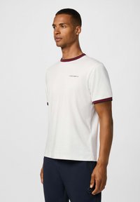 Biela krátkorpová tričko s vínovou rebrovanou golierom a manžetami na rukávoch, s malým logom "HACKETT" na hrudi. Hladká textúra látky.