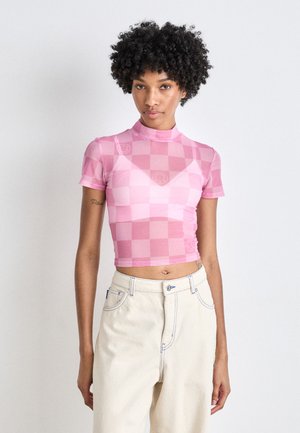 Haut ajusté à manches courtes dans un motif à carreaux rose clair avec un col montant. Confectionné dans un tissu lisse et extensible. Accentué par un logo brodé.