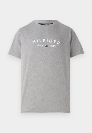 Harmaa puuvillapaita lyhyillä hihoilla, jossa on valkoinen "HILFIGER USA 1985" -grafiikka rinnassa ja pyöreä pääntie.