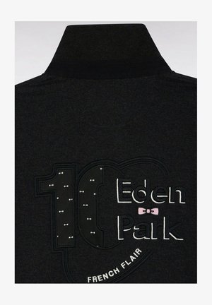 L'arrière de la veste noire montre "10 Eden Park" brodé avec de petits nœuds papillon blancs à l'intérieur du chiffre 10 et "French Flair" en dessous.