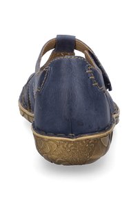 Scarpa in pelle blu navy con retro arrotondato, cuciture decorative e suola in bronzo testurizzata con motivi floreali.