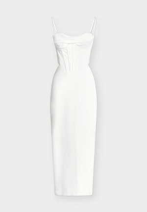 Balta vidēja garuma kleita bez piedurknēm ar plānām lencītēm, pieguļoša krūškurvja daļa ar struktūrētām šuvēm un taisna svārku daļa uz vienkrāsaina fona.