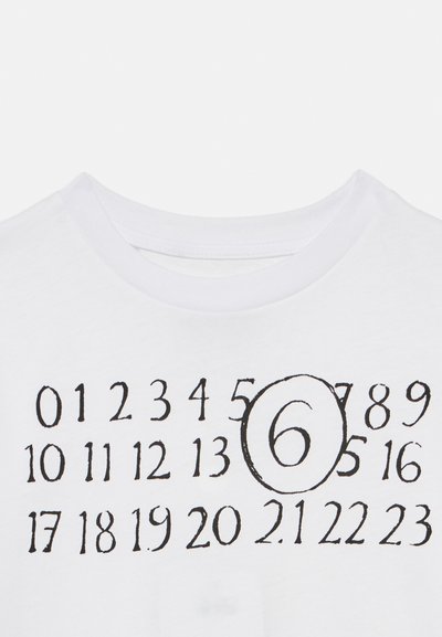 Λευκό βαμβακερό μπλουζάκι με σχέδιο πλέγματος από μαύρους τυπωμένους αριθμούς, με τον αριθμό "6" κυκλωμένο και εμφανώς στο κέντρο.