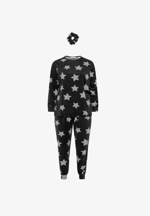 Sort velour pyjamasæt med hvide stjerne mønstre, bestående af en t-shirt med lange ærmer og tapered bukser, ledsaget af en matchende sort scrunchie.