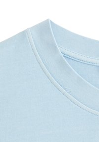 Lyseblå bomulds-T-shirt med en rund, ribbet krave. Stoffet har en glat tekstur og synlige sømme langs kanterne.