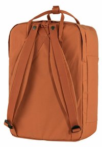 Oranžový batoh vyrobený z odolné tkaniny, s nastavitelnými popruhy, horní rukojetí a boční kapsou na úložný prostor. Hladký povrch.
