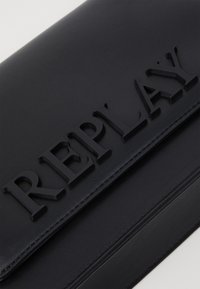 Schwarze Lederhandtasche mit erhabenem "REPLAY"-Schriftzug auf der Vorderseite. Strukturierte Form mit glatter Textur und sauberer Naht entlang der Kanten.