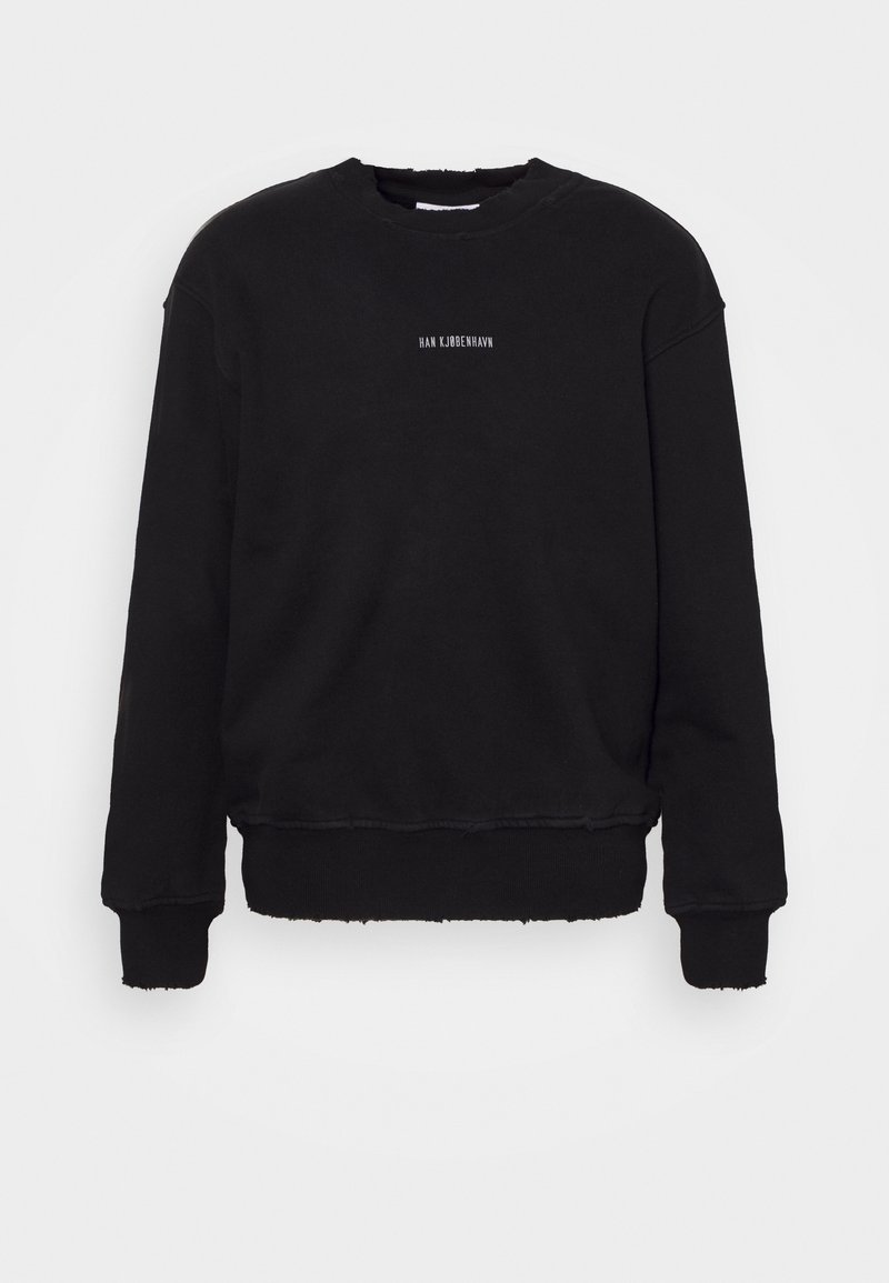 Svart långärmad crewneck sweatshirt med råa kanter och liten vit text "HAN KJØBENHAVN" centrerad på bröstet.