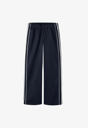 Pantalon bleu marine à jambes larges avec bandes blanches latérales et taille élastique, présenté sur fond blanc.
