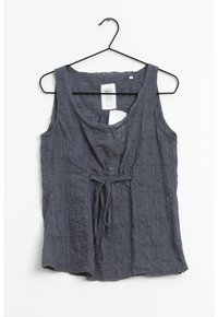 Šedý top bez rukávů s texturovaným vzorem, knoflíky vpředu a detailem na zavázání v pase, vyrobený z lehkého materiálu.