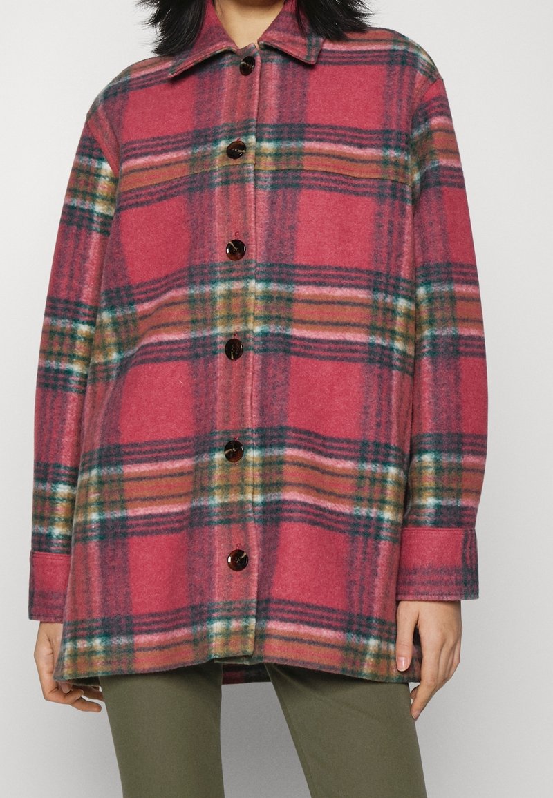 Plaid wool shirt jacket in pink and green hues, featuring a collar, long sleeves, and dark buttons along the front closure.