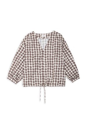 Blouse à manches longues avec col en V, ornée de pois marron sur tissu blanc, avec lien de serrage ajustable à l'ourlet.