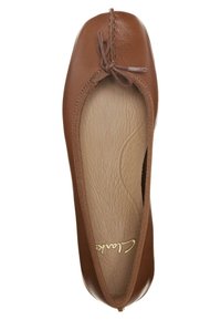 Bruine leren balletschoenen met een ronde neus en een dunne strikdetail. De binnenkant heeft een gestructureerde, lichtbruine voering.