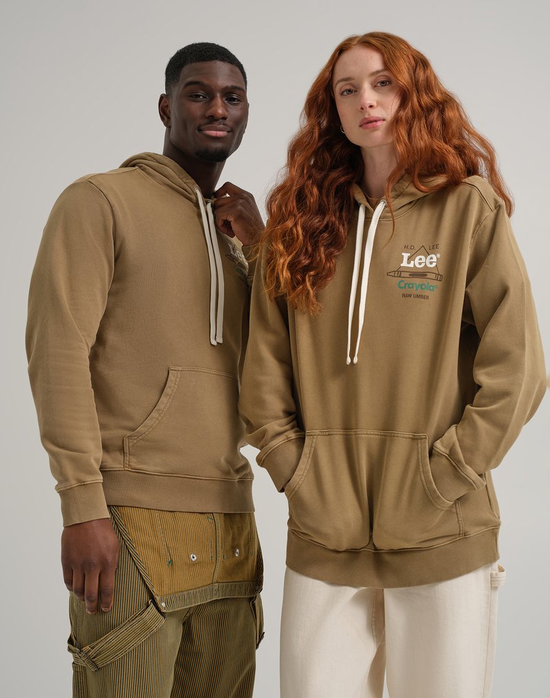 Due persone indossano felpe beige con tasche frontali, cappucci con cordino e dettagli stampati. L'abbigliamento dell'uomo include pantaloni a righe con tasche.