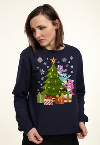 Felpa blu navy con una grafica colorata di un albero di Natale, comprendente orsi cartoon, regali e fiocchi di neve, stampata sul davanti.