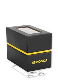 Boîte en carton noire avec une bande jaune, dotée d'une fenêtre transparente sur le dessus. Le nom de la marque "SEKONDA" est imprimé en jaune sur le devant.