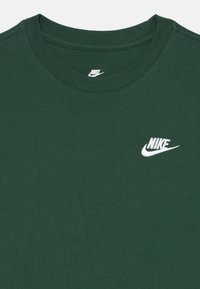 Dark green Nike crew-neck T-shirt with white embroidered Nike logo on the upper left chest and printed Nike logo inside the collar.