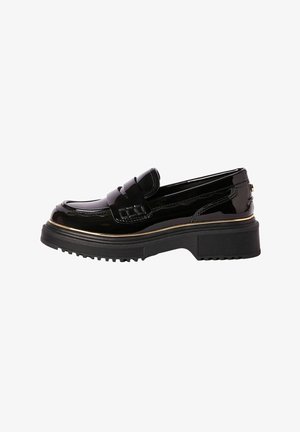 Mocassin en cuir verni noir avec semelle épaisse et bordure dorée le long du bord, vu de côté.