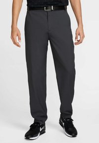Gray dress pants made of lightweight fabric with a straight cut. Features a smooth texture and a subtle crease; paired with black athletic shoes.