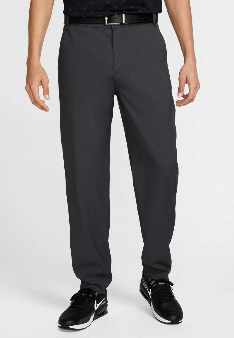 Gray dress pants made of lightweight fabric with a straight cut. Features a smooth texture and a subtle crease; paired with black athletic shoes.