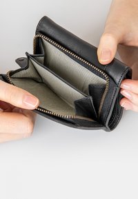 Schwarze Lederbörse mit Reißverschluss, ausgestattet mit einem gestreiften Innenfutter, mehreren Fächern und sichtbaren Nähten entlang der Kanten.