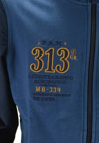 Felpa blu navy realizzata in tessuto morbido con ricami dorati. I testi notevoli includono "P.A.N. 313° GR." e "MB-339." Chiusura con zip sul davanti.
