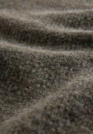 Rakenteellinen ruskea kangas, jolla on pörröinen ulkonäkö, pehmeä, lämmin kudonta ja hienovarainen kuosi. Materiaali on villamainen ja paksu.