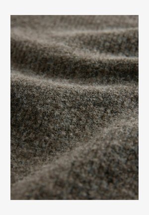 Kihiline pruun kangas, millel on karvane välimus, suudab tuua esile pehme, sooja kootud struktuuri ning peene mustri. Materjal on sarnane villaga ja paks.