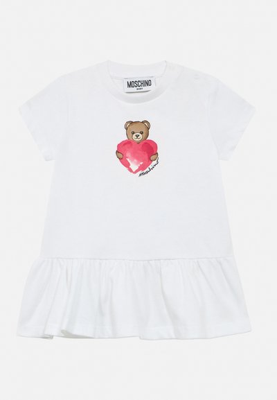 Robe blanche pour bébé avec manches courtes, ourlet à volants et un dessin d'ours en peluche tenant un cœur rouge sur la poitrine.
