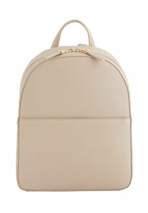 Mochila minimalista beige con parte superior redondeada, bolsillo frontal, cremallera dorada y pequeño asa superior.