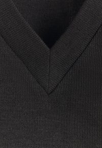 Tejido de punto negro con un acabado texturizado, que presenta un diseño de escote en V. La tela es suave y ligeramente elástica, lo que proporciona un ajuste ceñido.