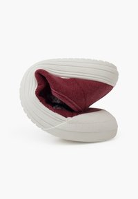 Scarpa slip-on in tela rossa con suola in gomma bianca, dotata di punta tonda e apertura elastica testurizzata. L'interno presenta una fodera in tessuto decorata.