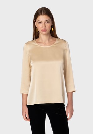 Beige satin top with a round neckline and three-quarter sleeves, featuring a smooth texture and a relaxed fit.