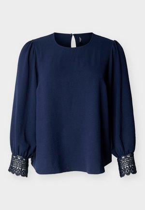 Blouse bleu marine à manches longues avec des poignets en dentelle, des manches bouffantes, un col rond et une petite fermeture par bouton à l'arrière.