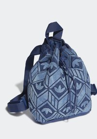 Jeansdragväska i olika nyanser av blått, med geometriska mönster och logotypdetaljer, samt justerbara remmar och dragsnöre upptill.