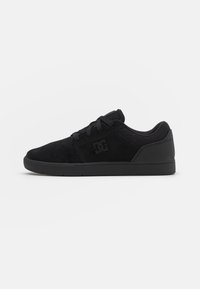 Black skate shoes made of suede with a low-profile design, rounded toe, lace-up closure, and textured rubber sole. Logo on the side.