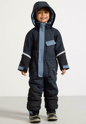 Tuta da neve impermeabile per bambini in blu navy scuro e azzurro chiaro. Caratterizzata da un cappuccio, strisce riflettenti, polsini regolabili e numerose tasche.