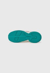 Shoe sole in teal rubber with textured grip pattern, featuring a cream-colored upper with black accents, designed for traction and support.