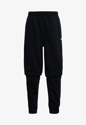 Schwarze Sweatpants mit einem elastischen Bund, tailliertem Bein Design und weißem Logodetail am linken Oberschenkel. Weicher Stoff.