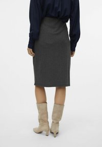 Grijze pinstripe kokerrok, gemaakt van zachte stof, kniehoog en gecombineerd met beige suède enkellaarsjes met een spitse neus en een kleine hak.