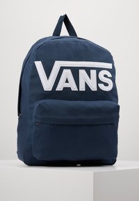 Zaino di stoffa blu con grande logo bianco "VANS", tasca frontale e manico superiore per il trasporto. Tessuto testurizzato con cuciture resistenti.