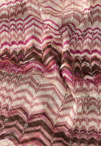 Tissu tricoté doux avec un motif en zigzag dans des nuances de rose, marron et crème, montrant des plis et la texture.