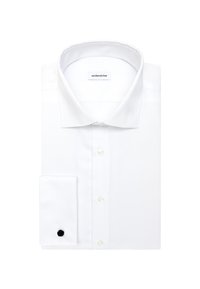 Chemise blanche à manches longues avec col classique, bouton de manchette noir sur une manchette et étiquette de marque visible à l'intérieur du col.