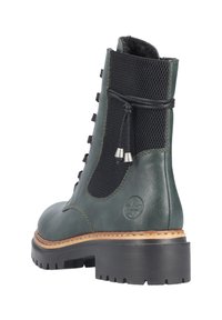 Bottine en cuir vert avec panneau en mesh noir, bout rond, design à lacets, semelle en caoutchouc et détails cousus le long du bord.