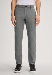 Grijze broek van textuurstof, met een recht gesneden ontwerp, knoopsluiting en zijzakken. Gepaard met zwarte sneakers.