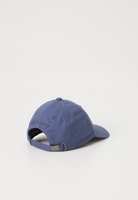 Casquette bleu marine en coton, dotée d'une bandoulière ajustable, d'un logo brodé à l'arrière et d'un bord pré-incurvé.