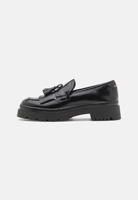 Schwarze lackierte Lederloafers mit einer robusten Gummisohle, die über ein markantes Quasten-Detail und gewellte Kanten verfügen.